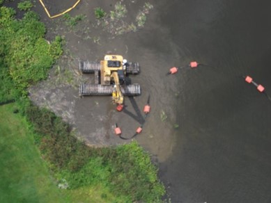 aerial photo of an excavator with pump in use along a shoreline